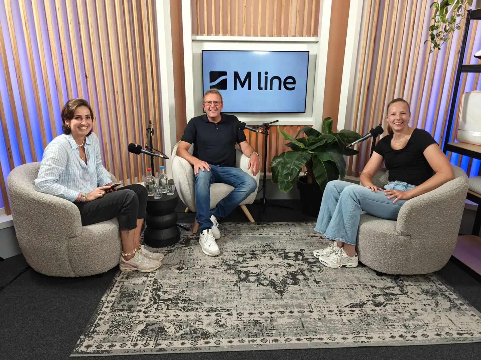 Drie gasten in gesprek tijdens een podcastopname in de studio